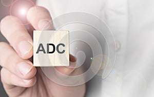 Man holding adc word on wooden cube photo