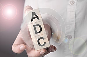 Man holding adc word on wooden cube photo