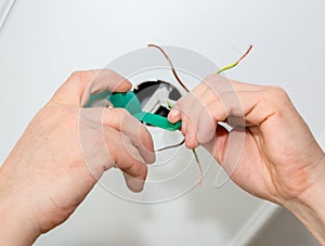 Man is holding adhesive tape in his hands.  Electrical insulator for light bulb. Maintenance repair works in the flat. Restoration