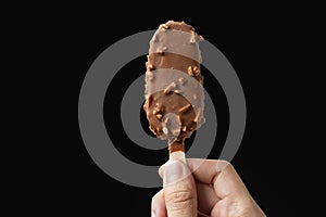Man Holding Almond Chocolate Ice-Cream Stick on iSolated Black B