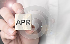 Man holding APR word on wooden cube