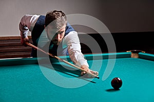 man holding arm on billiard table, playing snooker game or preparing aiming to shoot pool balls
