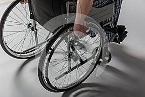 Man holding arms on armchair wheels