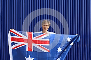 The man is holding Australia fabric flag in his hands