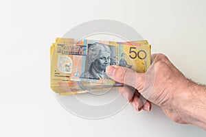 Man holding Australian Dollar banknote