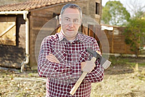 Man holding axe for chopping firewood in yard