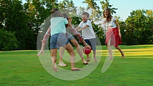 Man holding ball in hands outdoors. Mother with children trying to catch ball