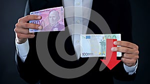 Man holding banknotes, euro falling relative to swiss franc, financial forecast