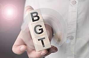 Man holding bgt word on wooden cube