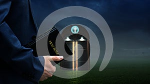 Man holding Bible in front of a glowing church door