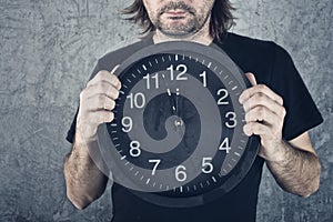 Man holding big black clock