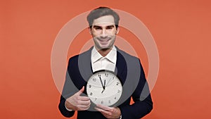 Man holding big wall clock and looking at camera with smile