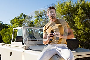 Man holding binocular on off road vehicle