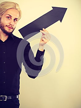 Man holding black arrow pointing right