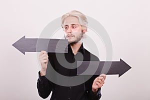 Man holding black arrows pointing left and right