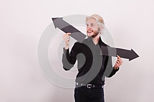 Man holding black arrows pointing left and right