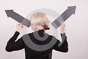 Man holding black arrows pointing left and right