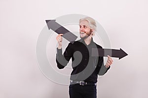 Man holding black arrows pointing left and right