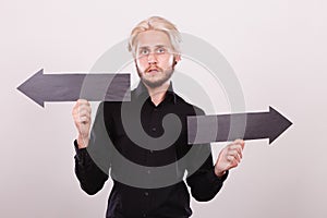 Man holding black arrows pointing left and right