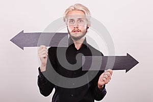 Man holding black arrows pointing left and right