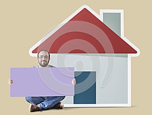 Man holding a blank icon with a house icon