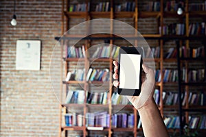 Man holding blank screen of a smartphone at the library.