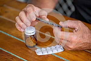 Man holding blister with pills and reading the instructions, medicine concept, targeted focus