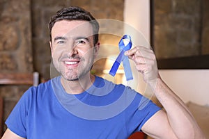 Man holding a blue ribbon