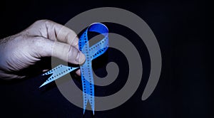 Man holding a blue ribbon, blue november concept