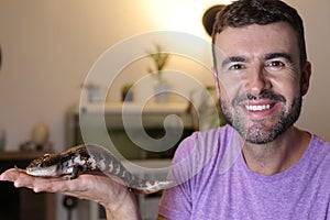 Man holding a `blue tongue lizard` or `tiliqua`
