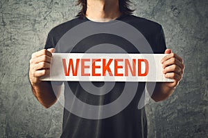 Man holding board with WEEKEND title