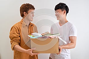 Man holding a book and clothes donate box. Donation concept.