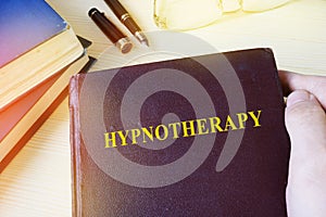 Man holding book with Hypnotherapy.