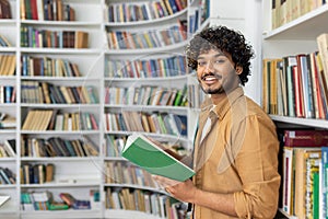 Man holding a book in a library full of shelves
