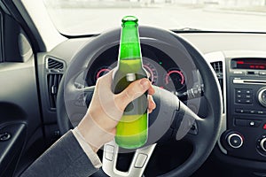 Man holding bottle of beer while driving