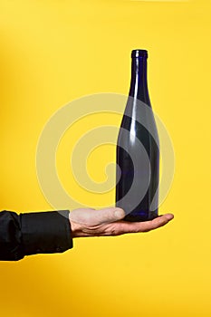 man holding a bottle on yellow background photo