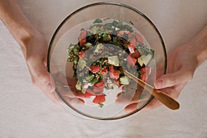 man holding a bowl of vegetable salad top view close-up