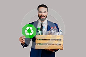 Man holding box with plastic bottles and recycling green symbol, sorting his rubbish, saving ecology