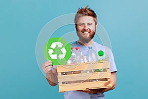 Man holding box with plastic bottles and recycling green symbol, sorting his rubbish, saving ecology