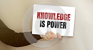 Man holding brochure with Knowledge is power text on grey background. Mock up for design