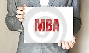 Man holding brochure with MBA text on grey background. Mock up for design