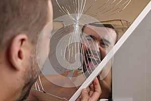 Man holding a broken mirror