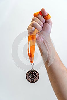 Man holding bronze medal on white background