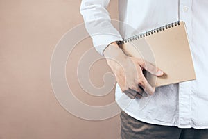 Man holding a brown notebook.