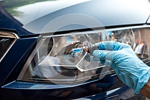 man holding bulb for repair car light