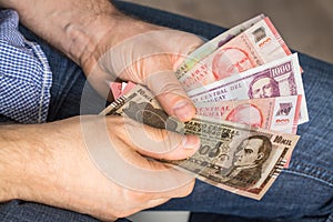 A man holding a bundle of Paraguay currency in his hands, Guaranies. Money of any value photo