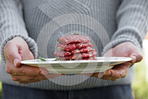 Man is holding burgers for BBQ