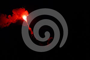 Man holding a burning red bonfire stick