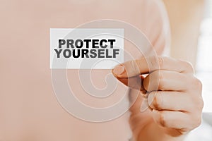 Man holding a business card with PROTECT YOURSELF