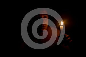 Man holding candle in dark